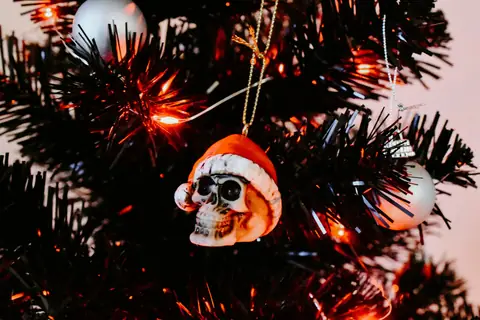 Santa-hat skull ornament on a black tree